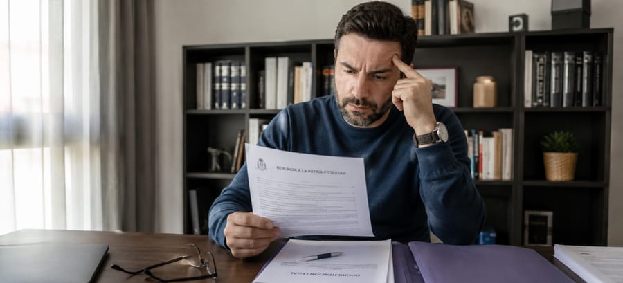 Padre mirando documentos legales sobre renuncia a la patria potestad en España